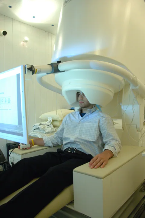 A person seated in a magnetoencephalography scanner